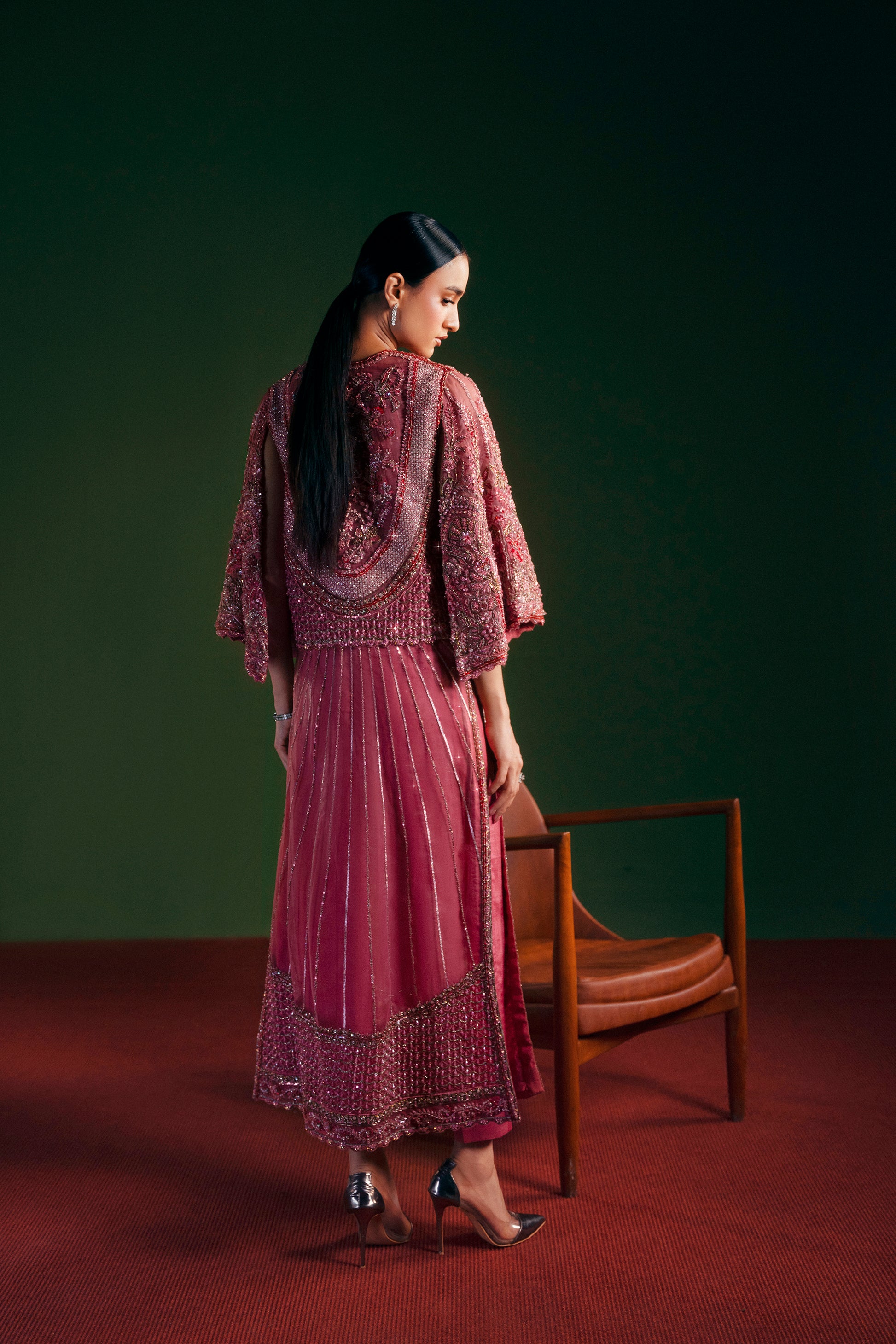 Woman in a patterned dress standing in a room with a green wall and wooden chair|premium women’s party wear with jacket and long shirt