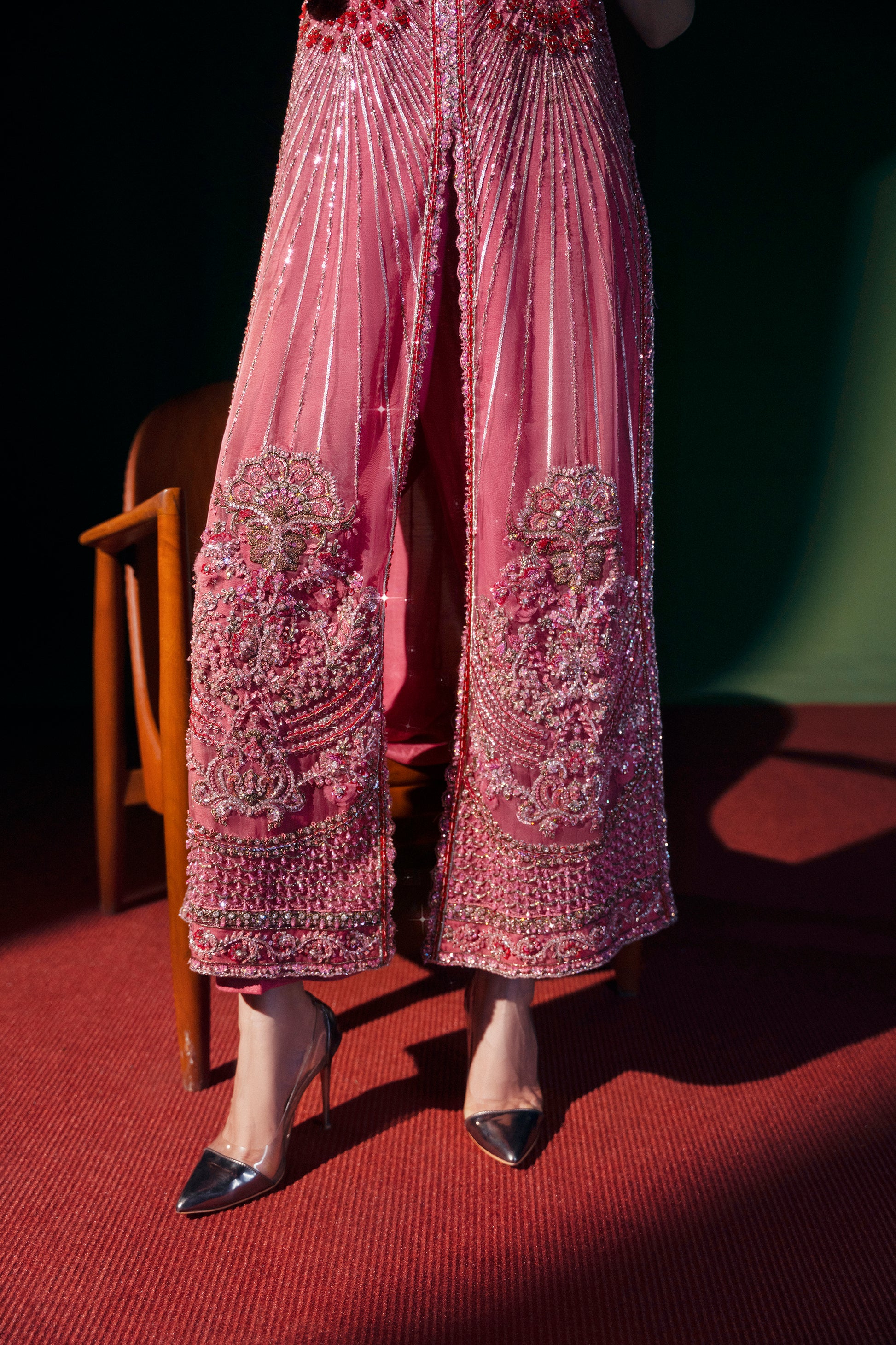 Person wearing a pink beaded outfit with a dark background|formal women’s clothing 3-piece ensemble bridal event wear